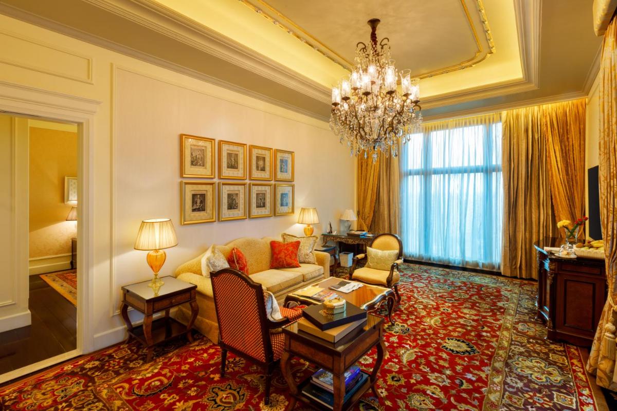 a living room with a couch and a chandelier at The Leela Palace New Delhi in New Delhi a living room with a couch and a chandelier at The Leela Palace New Delhi in New Delhi