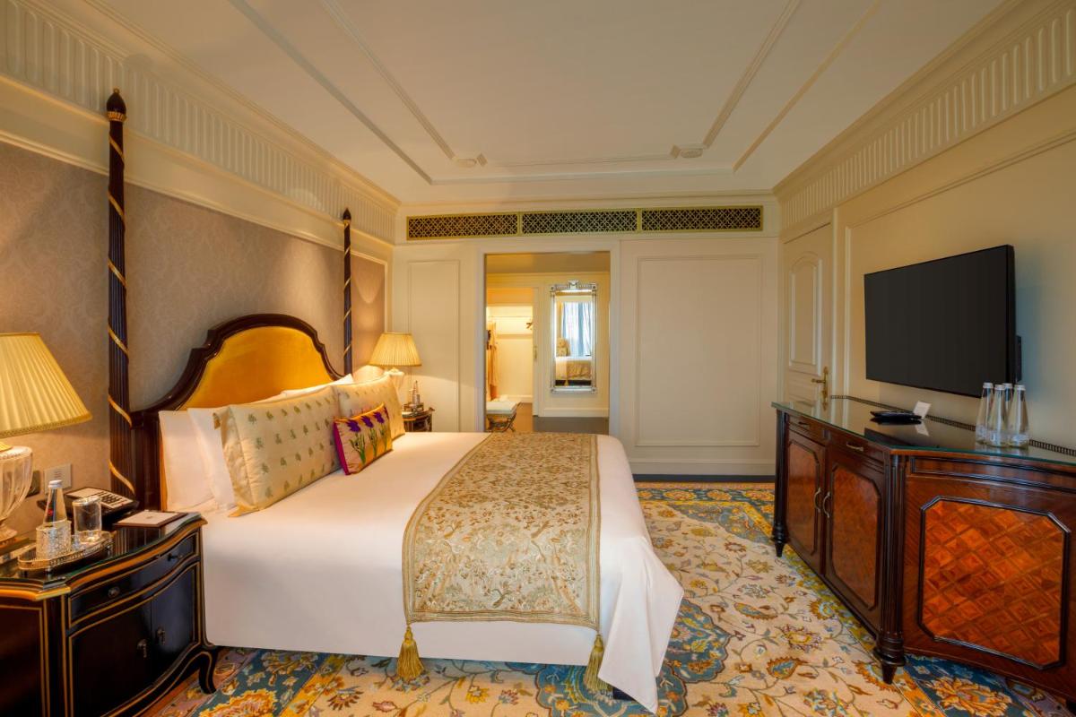 a bedroom with a large bed and a flat screen tv at The Leela Palace New Delhi in New Delhi a bedroom with a large bed and a flat screen tv at The Leela Palace New Delhi in New Delhi