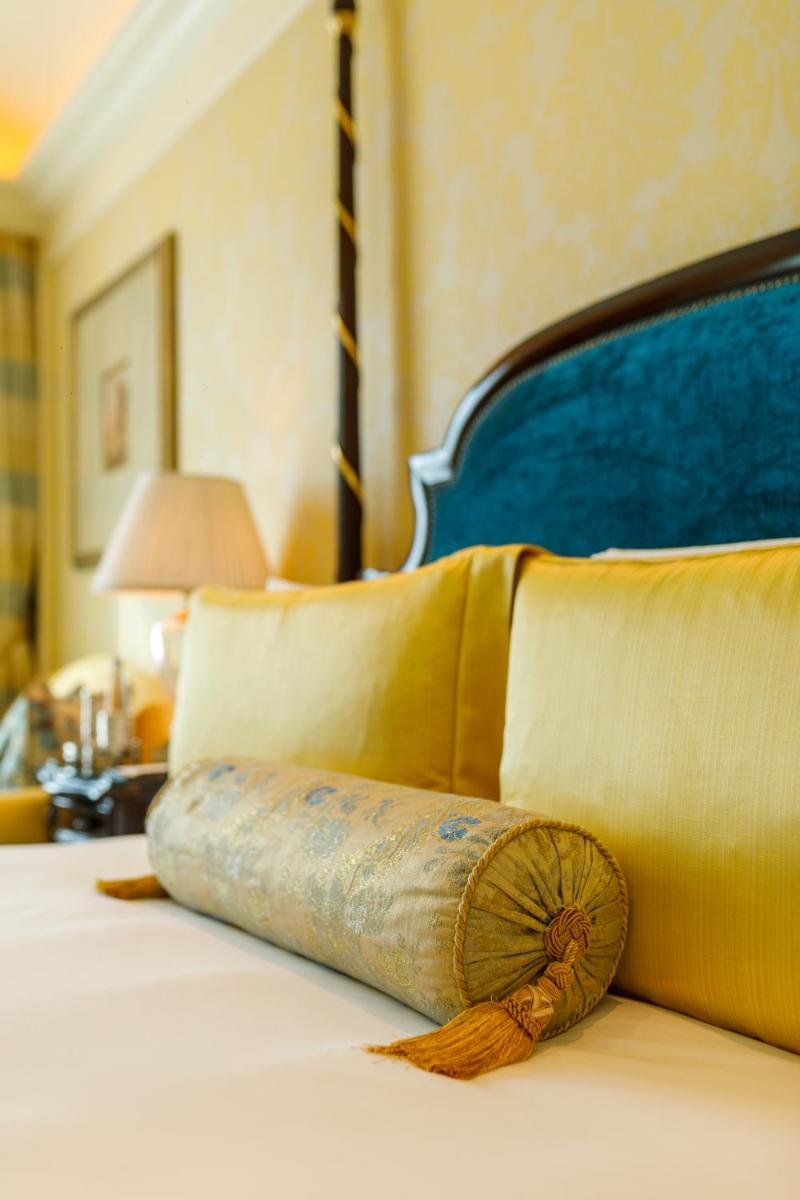 a bed with two pillows and aupuncture at The Leela Palace New Delhi in New Delhi a bed with two pillows and aupuncture at The Leela Palace New Delhi in New Delhi