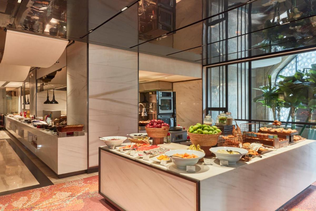 a buffet line with food on it in a restaurant at The Taj Mahal Tower, Mumbai in Mumbai a buffet line with food on it in a restaurant at The Taj Mahal Tower, Mumbai in Mumbai