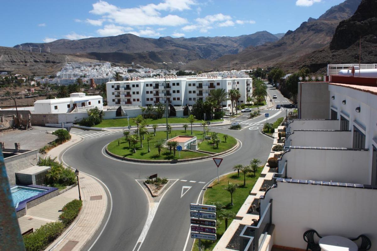 una calle vacía en una ciudad con montañas en el fondo en Hotel Puerto de Las Nieves, en Agaete