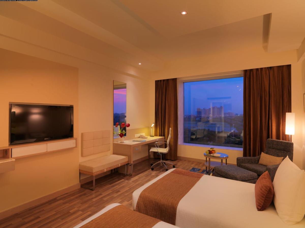 a hotel room with a bed and a flat screen tv at Radisson Blu Hotel, Greater Noida in Greater Noida
