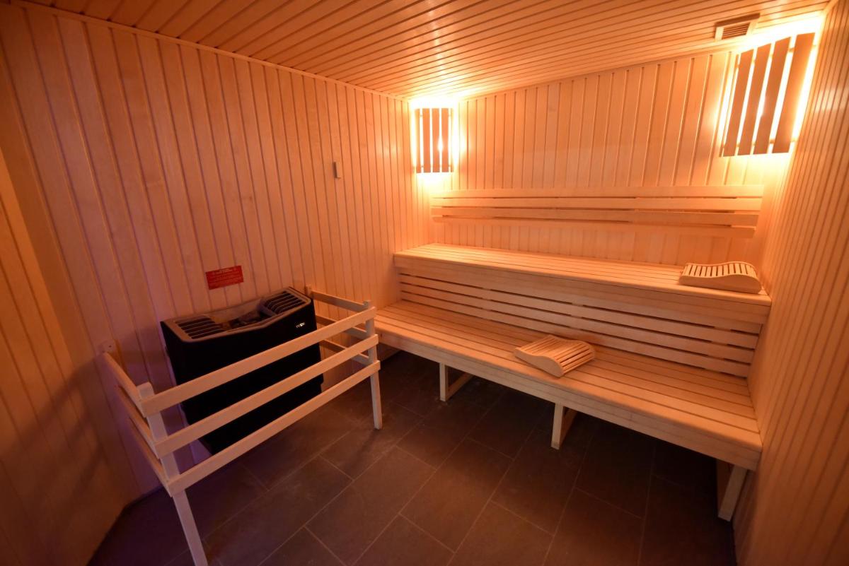 un sauna en bois avec un banc dans une pièce dans l'établissement Kyriad Hotel Dijon Gare, à Dijon