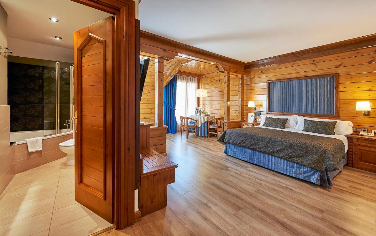Un dormitorio con una cama y un baño. en Hotel Grèvol Spa, en Camprodon