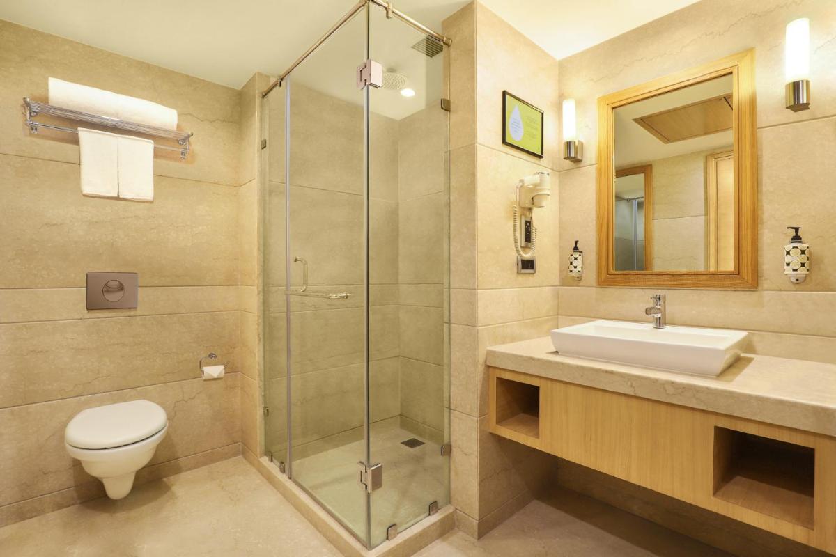 a bathroom with a toilet and a sink and a shower at Lemon Tree Premier, Delhi Airport in New Delhi a bathroom with a toilet and a sink and a shower at Lemon Tree Premier, Delhi Airport in New Delhi