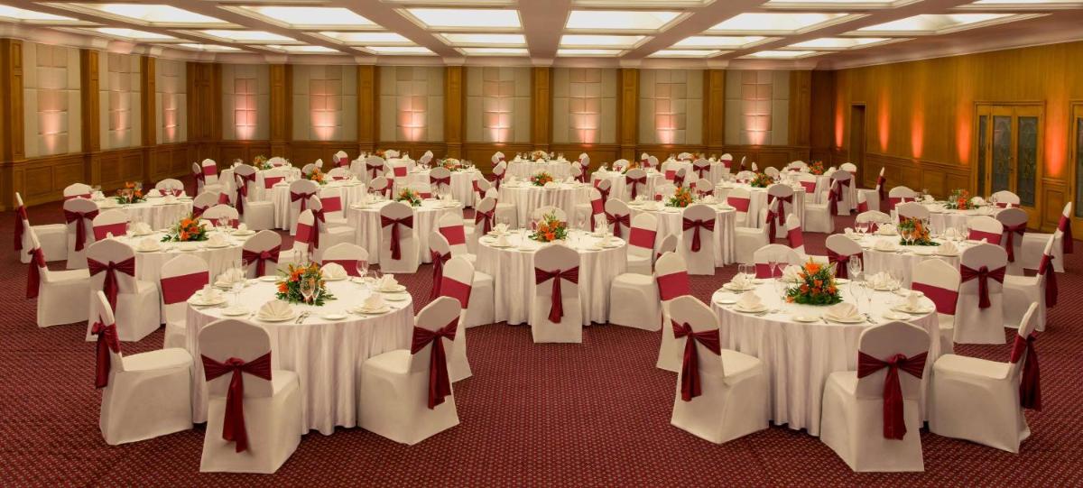 a room filled with tables and chairs with white tablecloths at Radisson Blu Kochi in Cochin