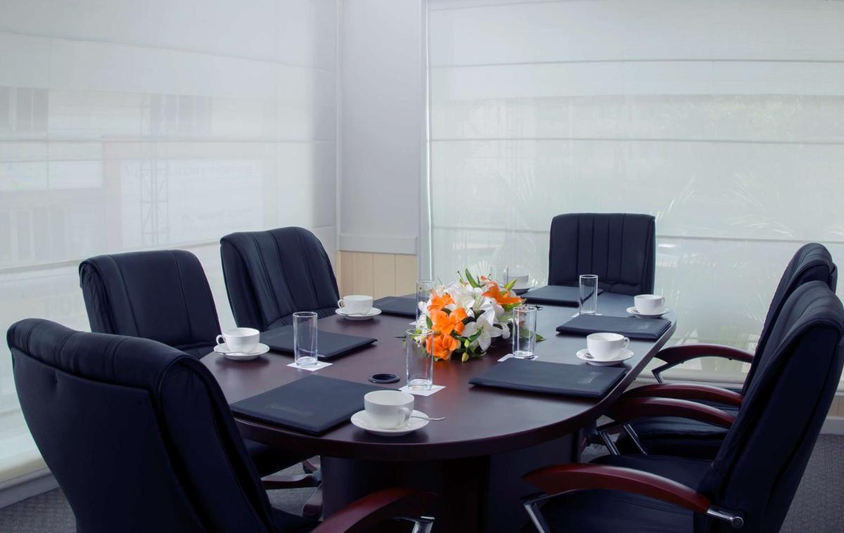 a meeting room with a table with chairs and flowers at Radisson Blu Kochi in Cochin