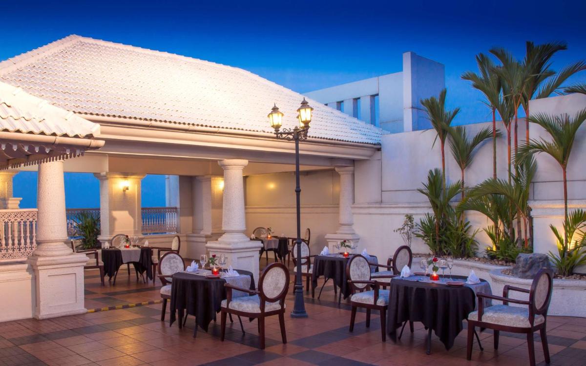 a restaurant with tables and chairs in front of a building at Radisson Blu Kochi in Cochin