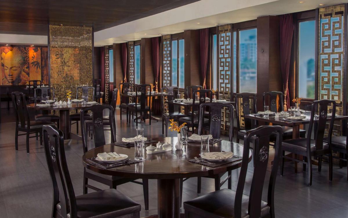 a restaurant with tables and chairs in a room at Radisson Blu Kochi in Cochin