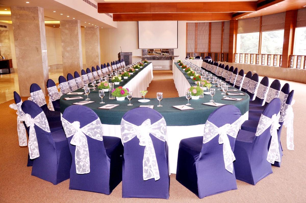a long table in a room with purple chairs and tables at Radisson Hotel Shimla in Shimla