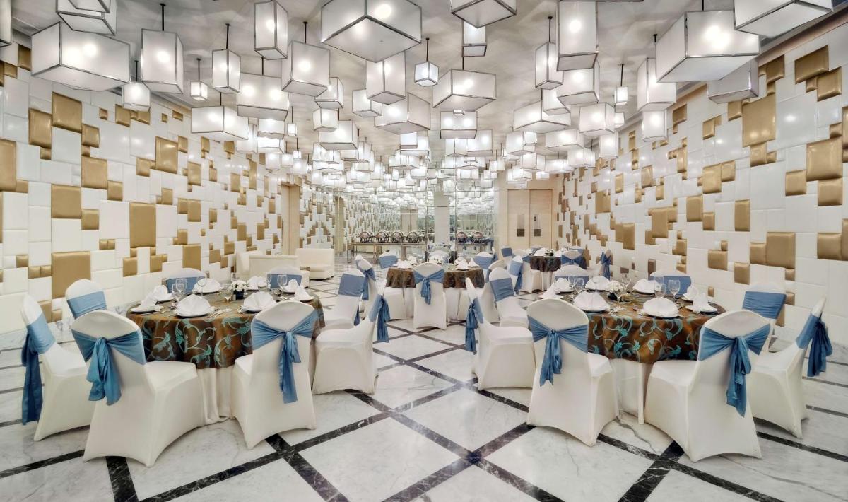 a banquet hall with tables and chairs in a room at Radisson Blu Hotel New Delhi Paschim Vihar in New Delhi +38 photos a banquet hall with tables and chairs in a room at Radisson Blu Hotel New Delhi Paschim Vihar in New Delhi +38 photos