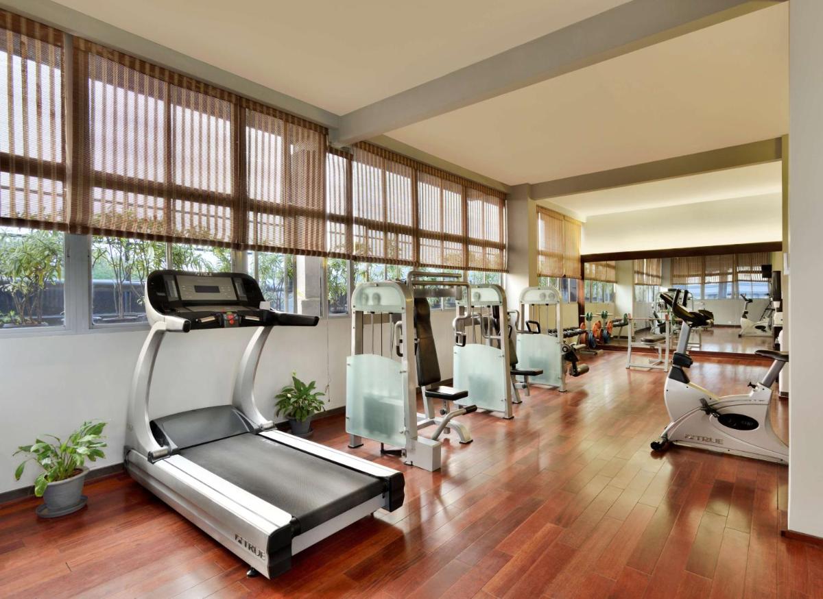 a gym with treadmills and elliptical machines at Radisson Blu Atria Bengaluru in Bengaluru a gym with treadmills and elliptical machines at Radisson Blu Atria Bengaluru in Bengaluru