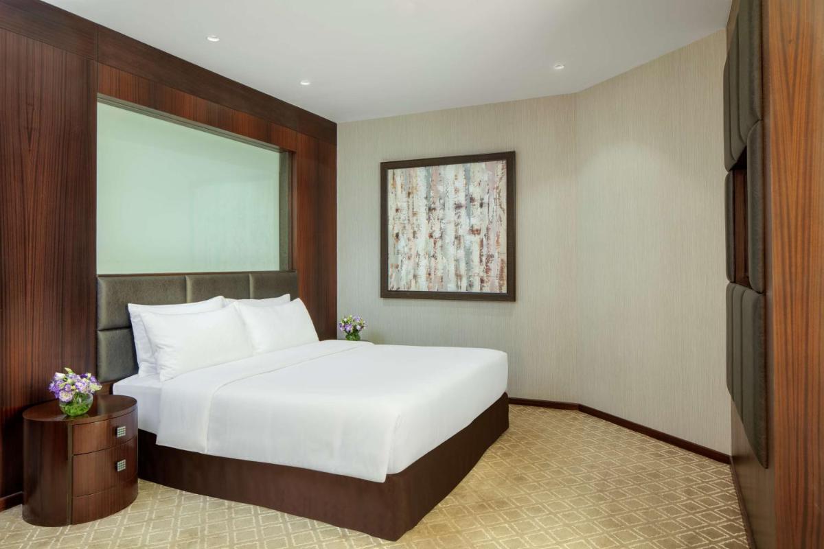 a bedroom with a white bed and a television at Radisson Blu Atria Bengaluru in Bengaluru a bedroom with a white bed and a television at Radisson Blu Atria Bengaluru in Bengaluru