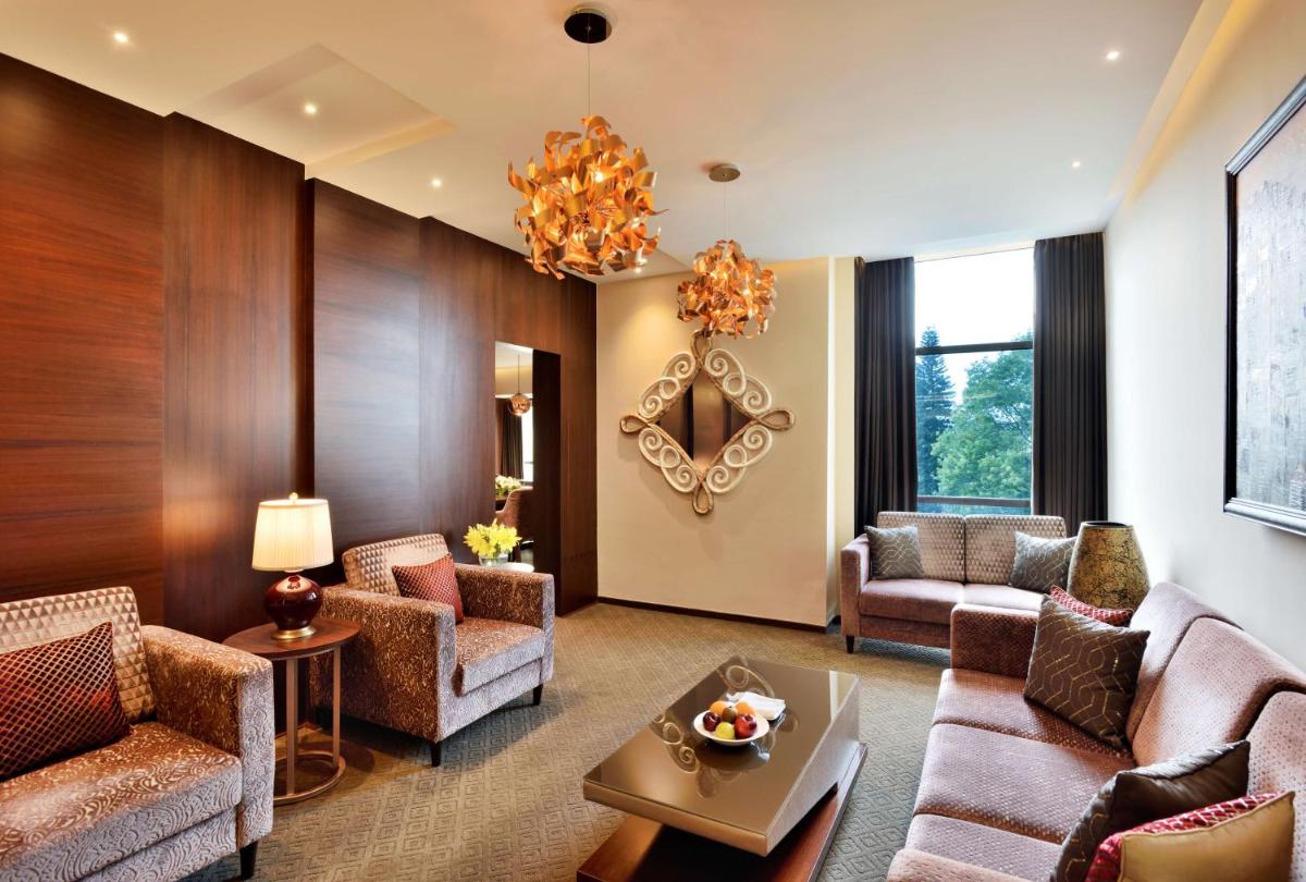 a living room with furniture and a chandelier at Radisson Blu Atria Bengaluru in Bengaluru a living room with furniture and a chandelier at Radisson Blu Atria Bengaluru in Bengaluru