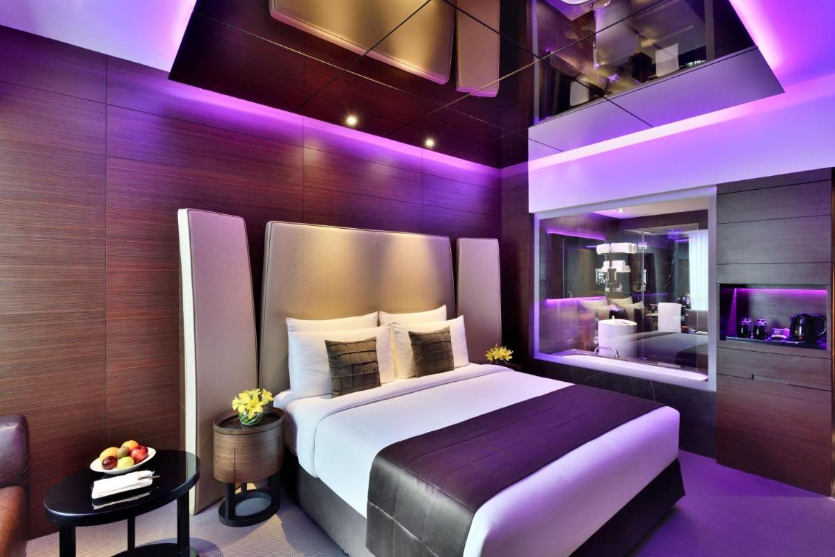 a bedroom with a large bed with purple lighting at Radisson Blu Atria Bengaluru in Bengaluru a bedroom with a large bed with purple lighting at Radisson Blu Atria Bengaluru in Bengaluru