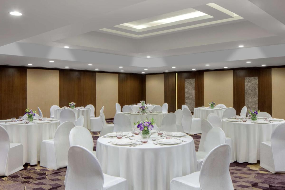 a banquet hall with white tables and white chairs at Radisson Blu Atria Bengaluru in Bengaluru a banquet hall with white tables and white chairs at Radisson Blu Atria Bengaluru in Bengaluru