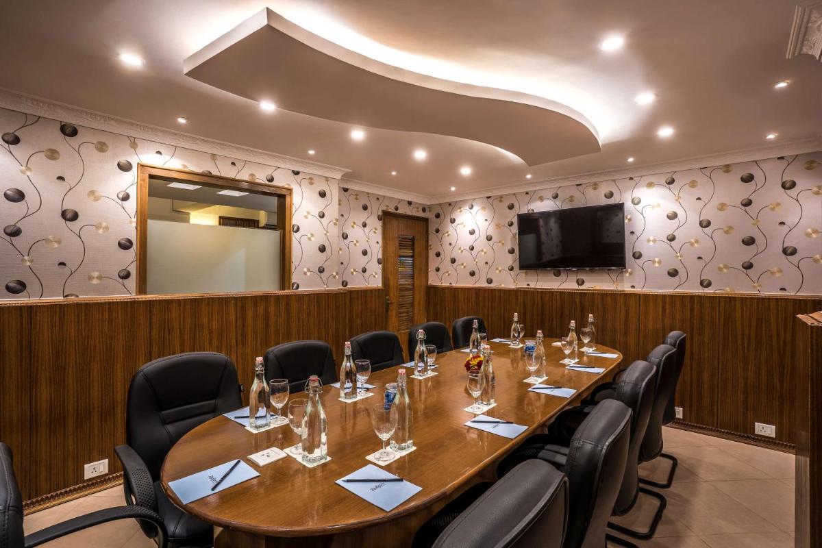 a conference room with a large wooden table and chairs at Radisson Goa Candolim in Candolim