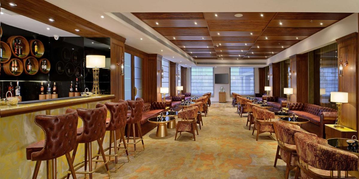 a bar with a row of chairs and tables in a room at Radisson Chandigarh Zirakpur in Chandīgarh