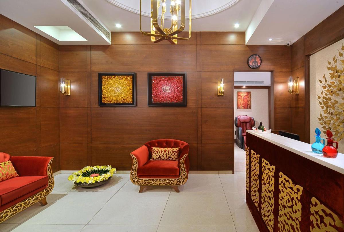 a lobby with two red chairs and a bar at Radisson Chandigarh Zirakpur in Chandīgarh