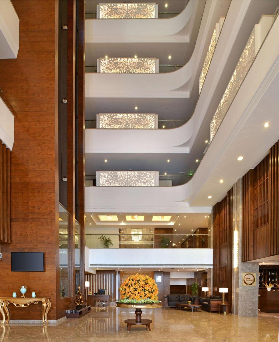 a lobby of a hotel with a large ceiling at Radisson Chandigarh Zirakpur in Chandīgarh