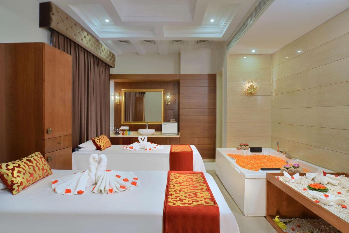 a hotel room with two beds and a mirror at Radisson Chandigarh Zirakpur in Chandīgarh