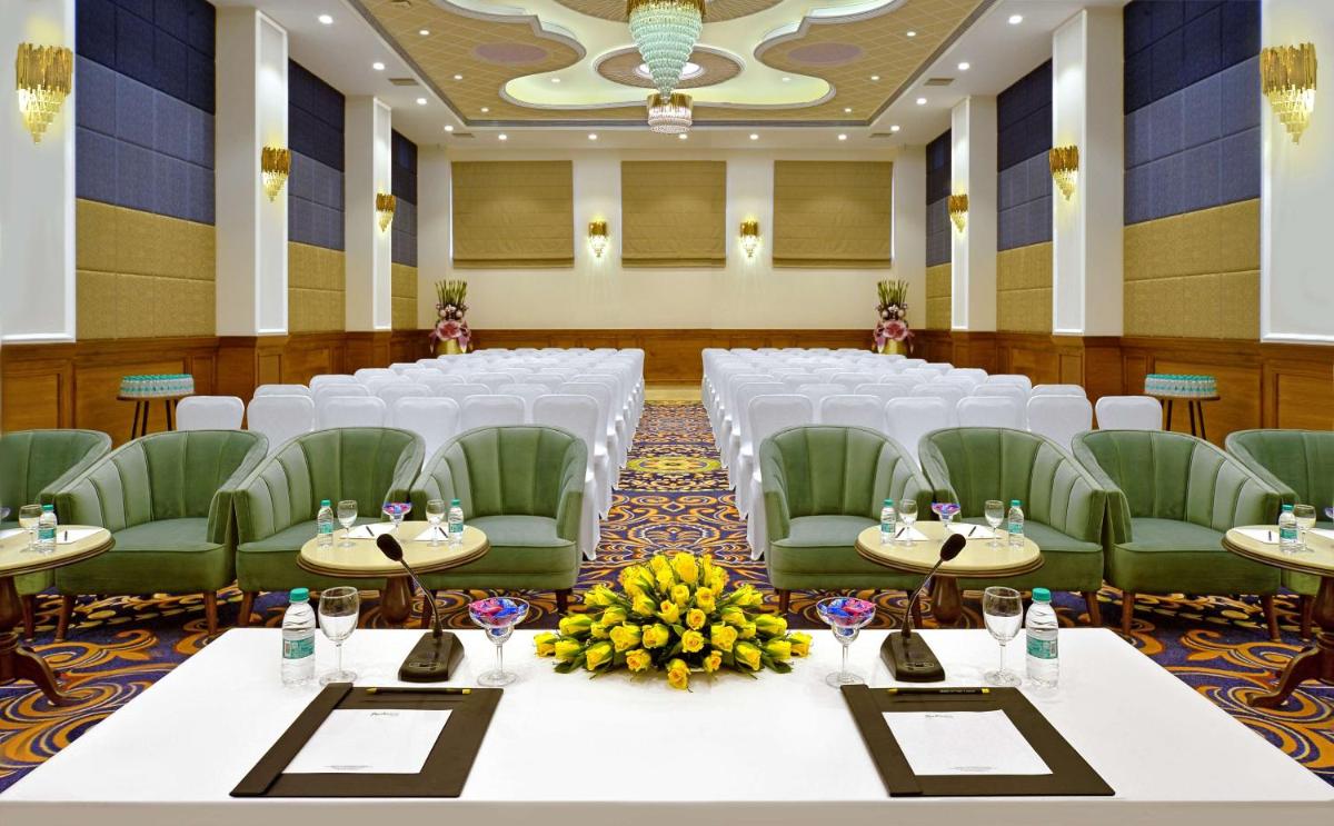 a banquet hall with white tables and green chairs at Radisson Chandigarh Zirakpur in Chandīgarh