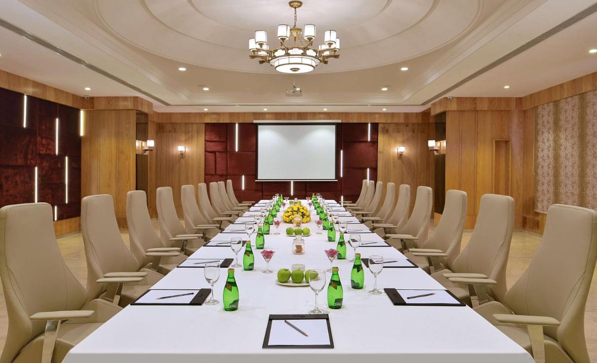 a long table in a room with chairs and a projection screen at Radisson Chandigarh Zirakpur in Chandīgarh