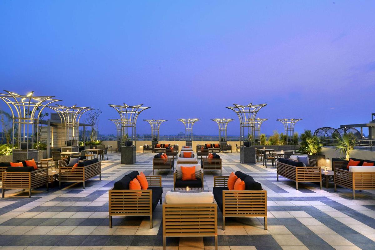 a resort with chairs and tables on a patio at Radisson Chandigarh Zirakpur in Chandīgarh