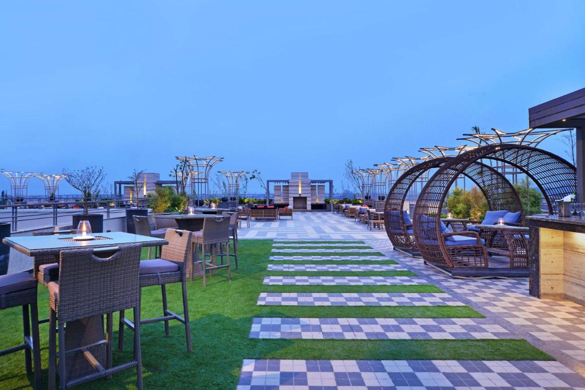 a patio with tables and chairs on a roof at Radisson Chandigarh Zirakpur in Chandīgarh
