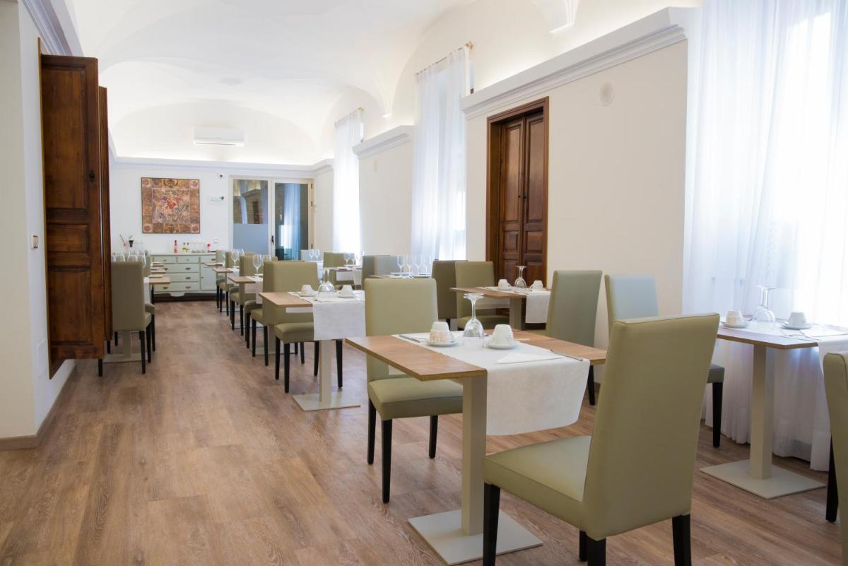Un comedor con mesas y sillas en una habitación. en Hotel Balneario El Raposo, en Puebla de Sancho Pérez