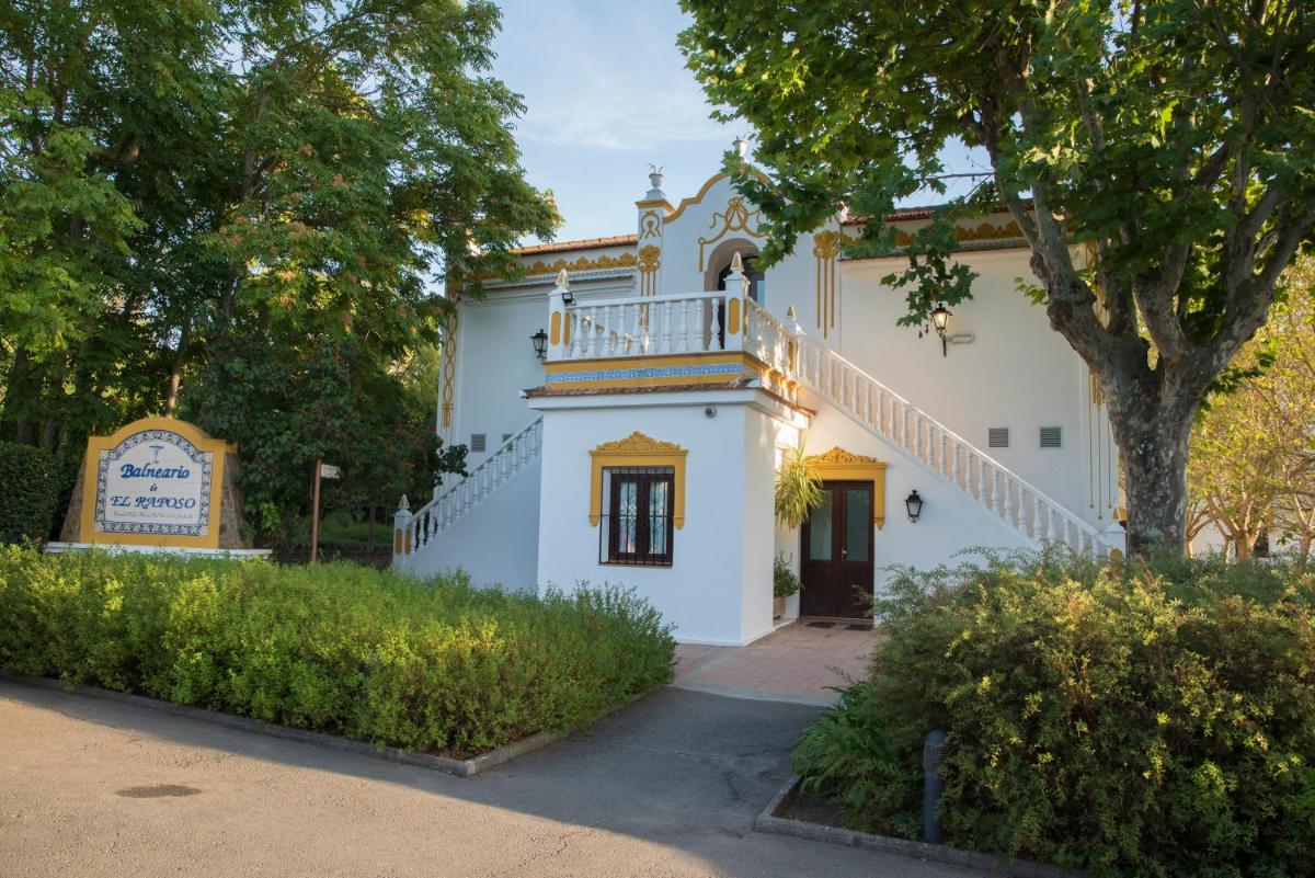 Una casa blanca con una escalera en el lateral. en Hotel Balneario El Raposo, en Puebla de Sancho Pérez