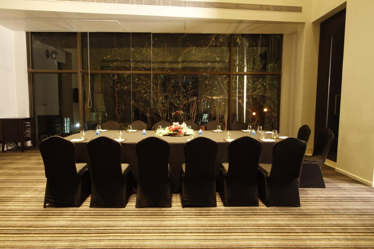 a table with black chairs in a room at Crowne Plaza Pune City Centre by IHG in Pune