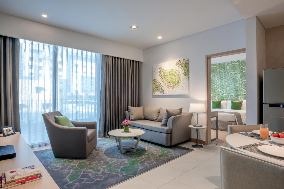 a living room with a couch and chairs and a table at Citadines OMR Chennai in Chennai a living room with a couch and chairs and a table at Citadines OMR Chennai in Chennai