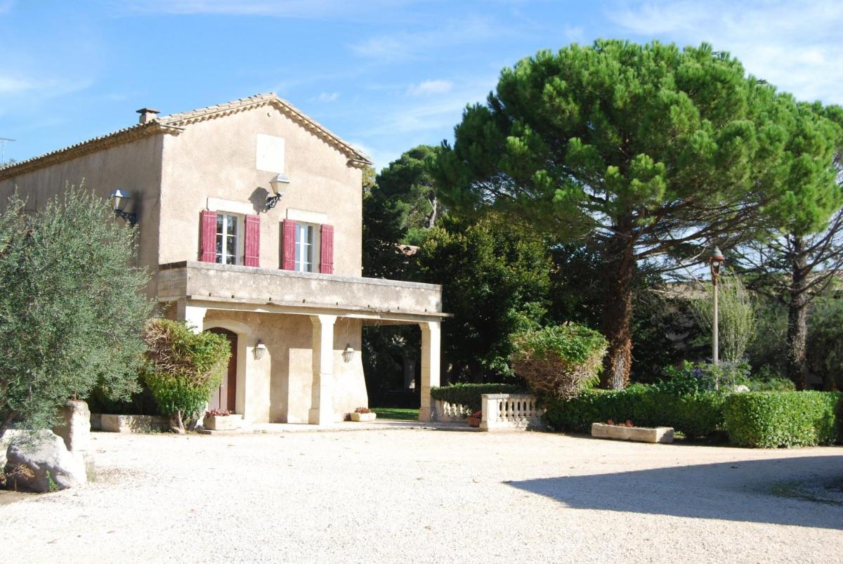 une maison avec une fenêtre rouge et un arbre dans l'établissement Domaine du Grand Malherbes, à Aimargues