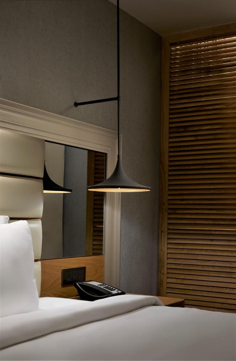 a bedroom with a bed and a mirror at The Residency Towers Puducherry in Puducherry