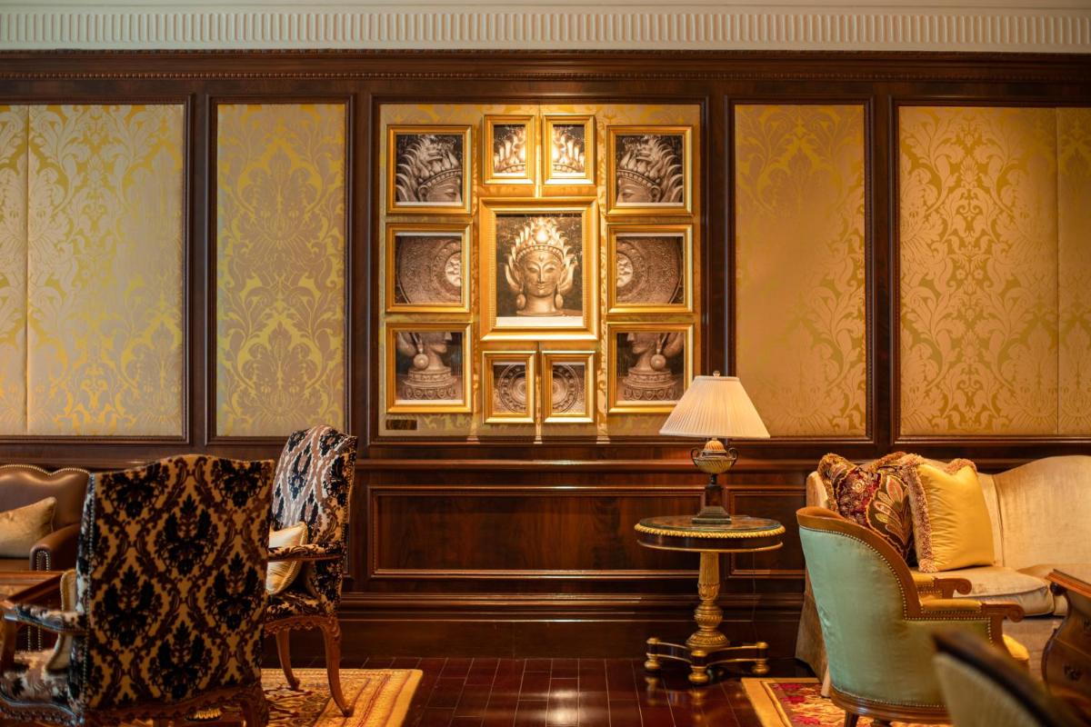 a living room with chairs and portraits on the wall at The Leela Palace New Delhi in New Delhi a living room with chairs and portraits on the wall at The Leela Palace New Delhi in New Delhi