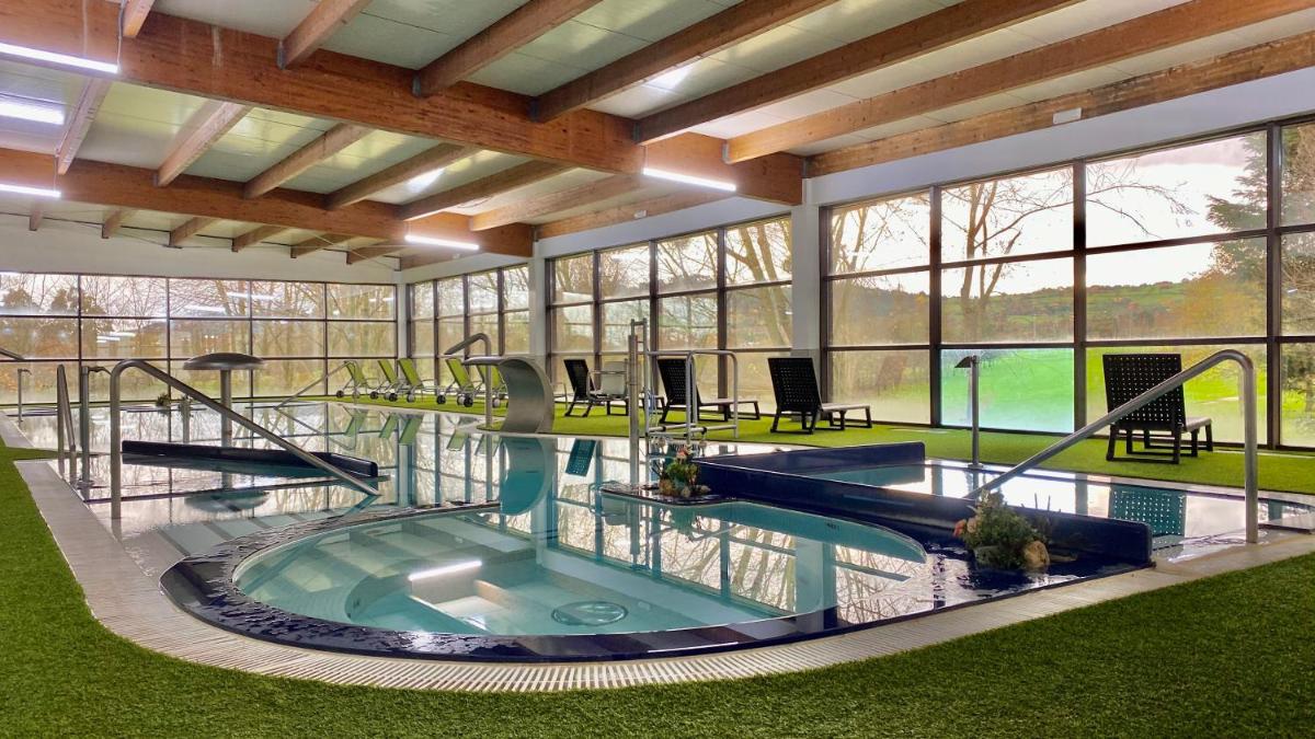 Una gran piscina cubierta en un edificio con ventanas. en Oca Palacio De La Llorea Hotel & Spa, en Deva