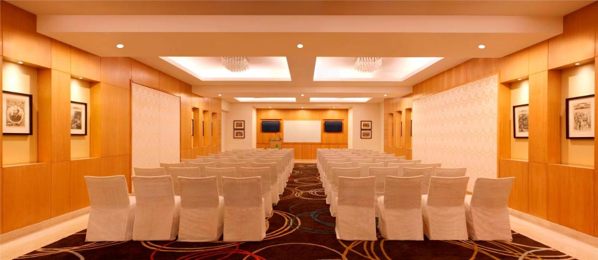 a conference room with white chairs in it at Lemon Tree Premier, Delhi Airport in New Delhi a conference room with white chairs in it at Lemon Tree Premier, Delhi Airport in New Delhi