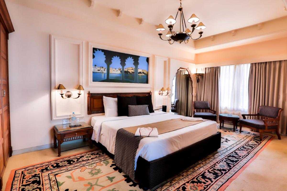a hotel room with a large bed and a chandelier at Sun-n-Sand Mumbai Juhu Beach in Mumbai