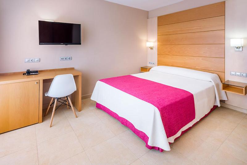 Un dormitorio con una cama, un escritorio y un televisor. en Mediterraneo Bay Hotel & Resort, en Roquetas de Mar 70 fotos más