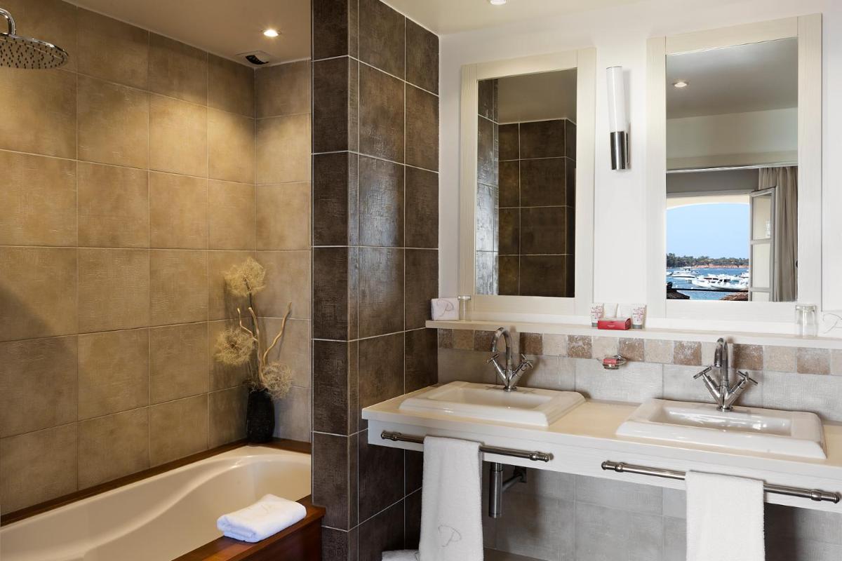 une salle de bains avec deux lavabos et une baignoire dans l'établissement Le Pinarello, à Sainte-Lucie de Porto-Vecchio