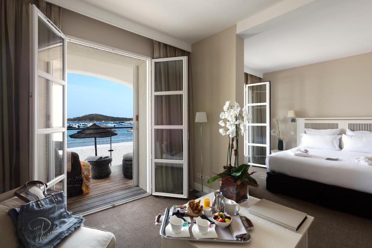 une chambre d'hôtel avec un lit et une vue sur l'océan dans l'établissement Le Pinarello, à Sainte-Lucie de Porto-Vecchio