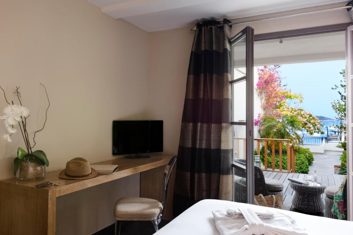 une chambre avec un lit et une fenêtre donnant sur un balcon dans l'établissement Le Pinarello, à Sainte-Lucie de Porto-Vecchio
