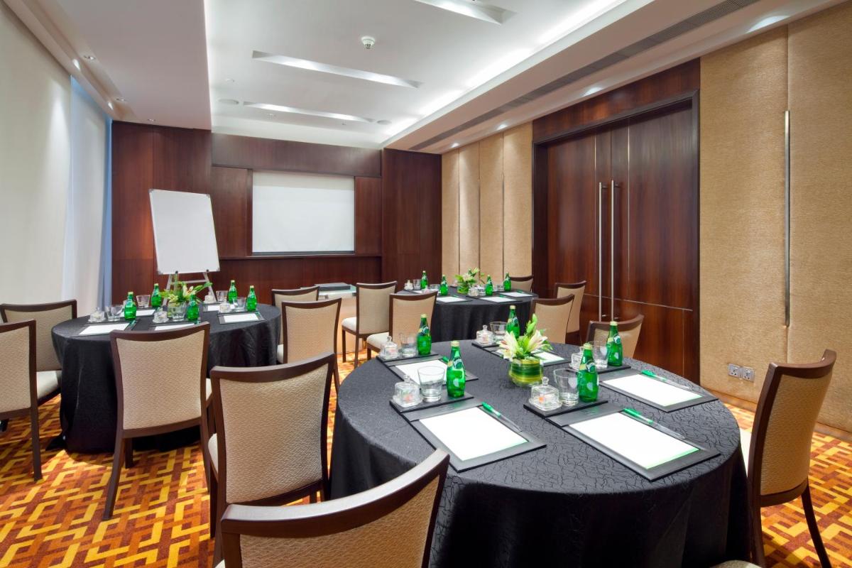 a conference room with long tables and chairs at Holiday Inn Mumbai International Airport by IHG in Mumbai a conference room with long tables and chairs at Holiday Inn Mumbai International Airport by IHG in Mumbai