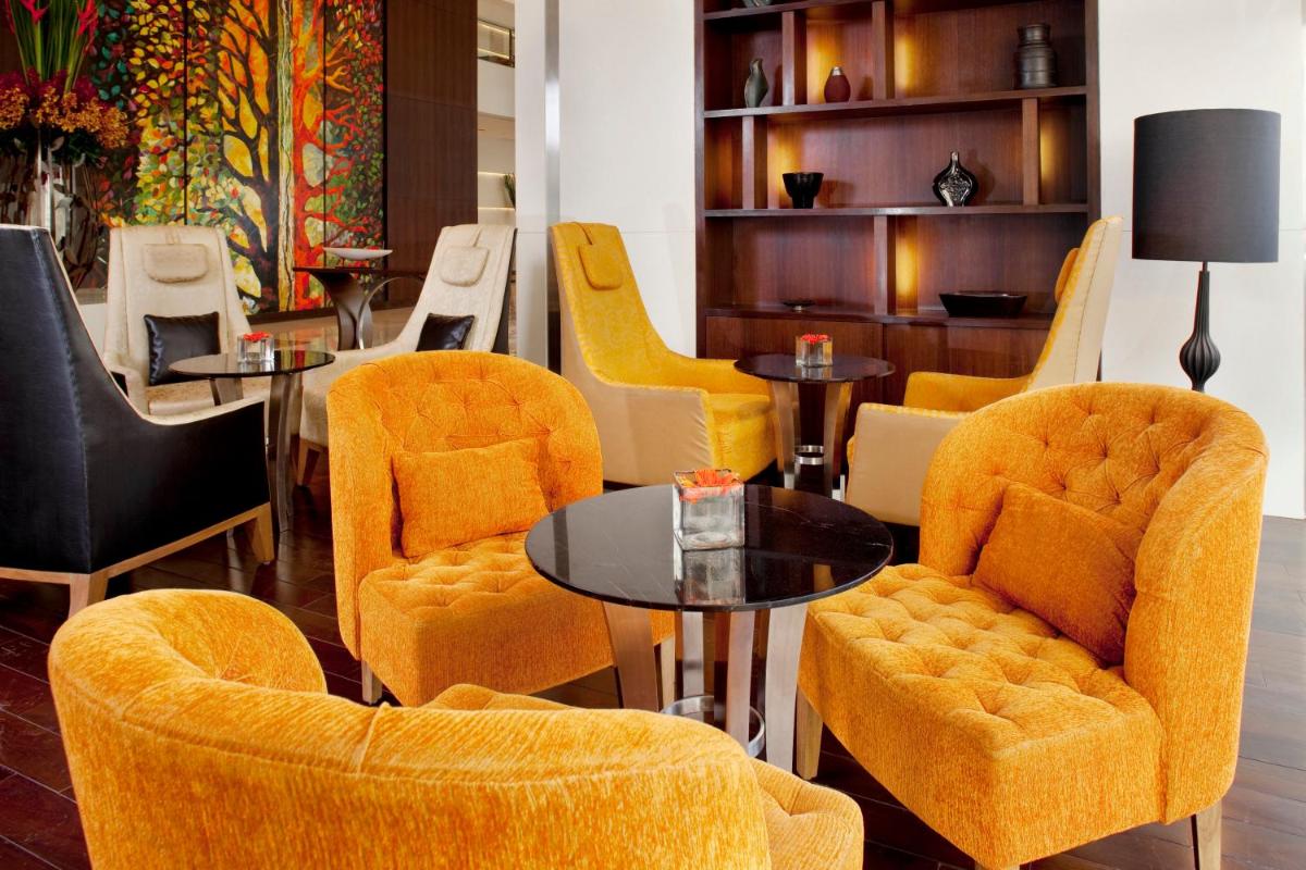 a group of chairs and tables in a room at Holiday Inn Mumbai International Airport by IHG in Mumbai