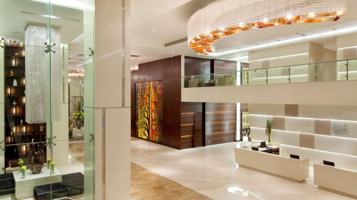 a lobby of a building with a chandelier at Holiday Inn Mumbai International Airport by IHG in Mumbai