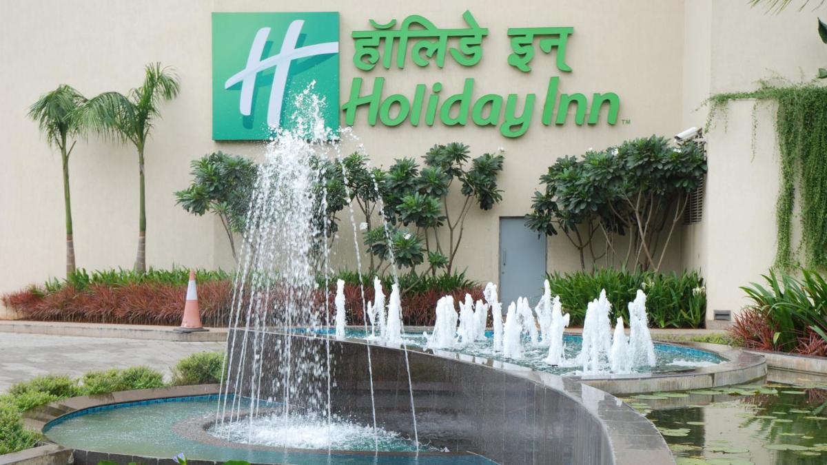 a fountain in front of a building with a sign at Holiday Inn Mumbai International Airport by IHG in Mumbai