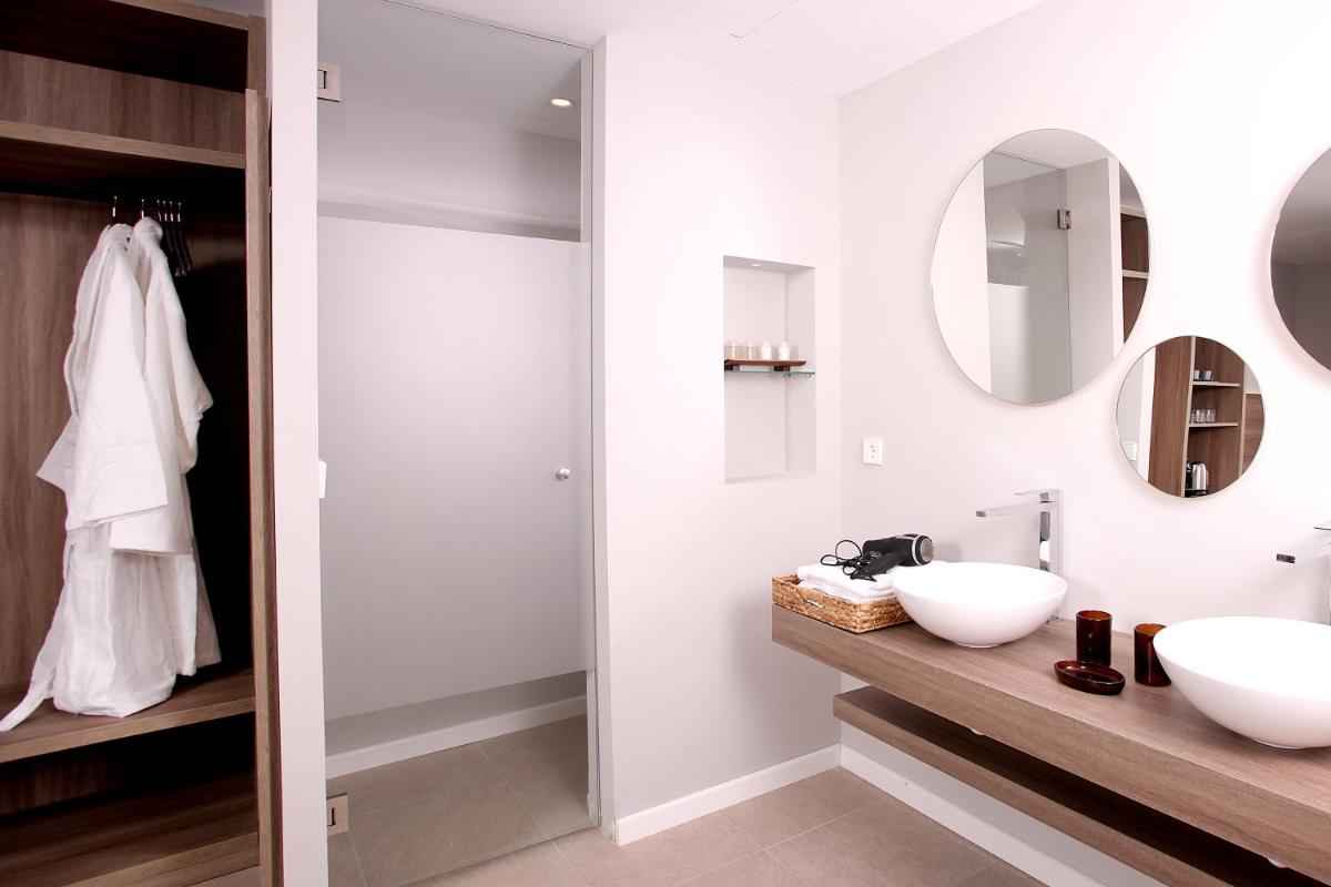 Un baño con dos lavabos y un espejo. en Eques Petit Resort, en Cala d´Or