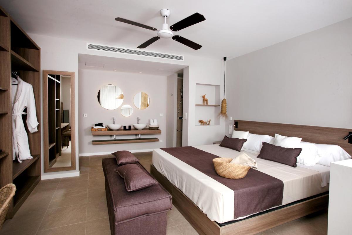 Un dormitorio con una cama grande y un ventilador de techo. en Eques Petit Resort, en Cala d´Or 72 fotos más
