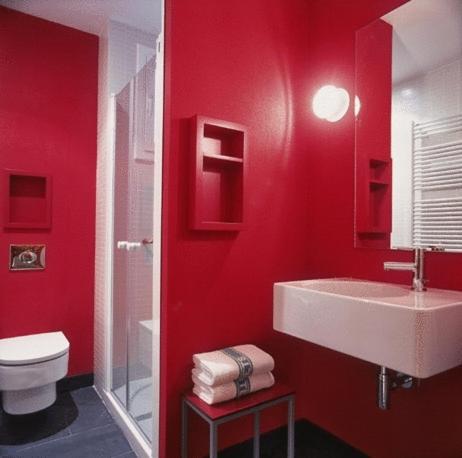 Baño rojo con lavabo y aseo en Hotel Restaurant Pessets & SPA, en Sort